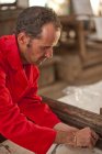 Плотник, работающий на деревянной раме — стоковое фото