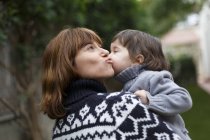 Mother and daughter kissing on cheek — Stock Photo