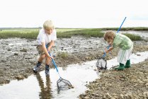 Due ragazzi che giocano in torrente con le reti — Foto stock