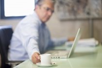Homme d'affaires mature prenant une pause café dans le bureau — Photo de stock