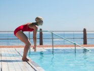 Jovem mulher mergulhando na piscina — Fotografia de Stock