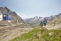 Jeune couple de randonneurs et téléphérique au glacier Val Senales, Val Senales, Tyrol du Sud, Italie — Photo de stock
