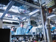 Científicos ajustando osciloscopio en laboratorio - foto de stock