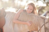 Молода жінка торкається коня, крупним планом — стокове фото