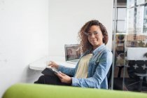 Портрет молодої жінки за допомогою цифрового планшета на офісному столі — стокове фото