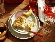 Plate with spanish omelette and lemon slices — Stock Photo