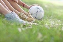 Обрезанный снимок молодых женских ног и футбольного мяча — стоковое фото