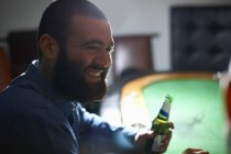 Sobre la vista del hombro de los hombres bebiendo cerveza en la mesa de la tarjeta del pub - foto de stock