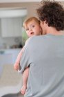 Father cuddling baby at home — Stock Photo