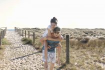 Homme donnant jeune femme piggyback, Port Melbourne, Melbourne, Australie — Photo de stock