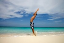 Man practicing yoga on tropical beach — Stock Photo