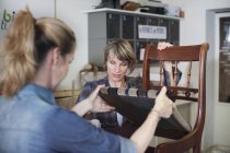 Frauen in Werkstatt untersuchen Stuhl — Stockfoto