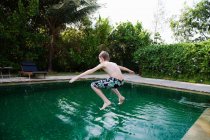 Niño saltando en la piscina - foto de stock