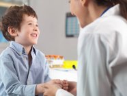 Arzt tröstet kleinen Jungen in Klinik — Stockfoto
