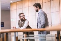Zwei Geschäftsleute unterhalten sich auf Bürobalkon — Stockfoto