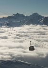 Cable car moving up from mountain fog — Stock Photo