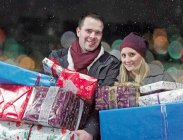 Paar mit Weihnachtsgeschenken im Schnee — Stockfoto