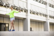 Young woman walking on wall — Stock Photo