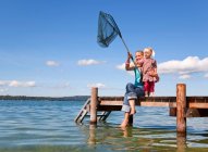 Madre e hija pescando con red - foto de stock
