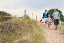 Famille marchant ensemble sur la plage — Photo de stock