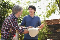 Father and adult son making pizza dough — Stock Photo