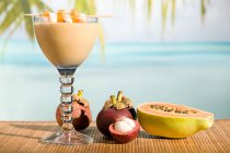 Glas Cocktail mit tropischen Früchten im Sonnenlicht — Stockfoto