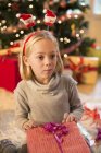 Mädchen hält Weihnachtsgeschenk zu Hause — Stockfoto