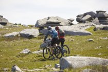 Ciclistas en bicicleta en ladera rocosa - foto de stock