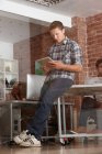 Молодой человек использует цифровой планшет в современном офисе — стоковое фото