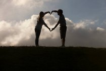 Couple forming heart shape with hands — Stock Photo
