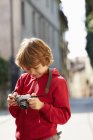 Мальчик проверяет фотографии на улице, провинция Венеция, Италия — стоковое фото
