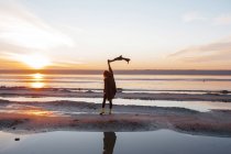 Жінка насолоджується пляжем на заході сонця — стокове фото