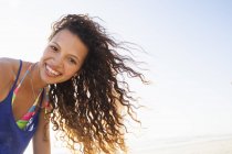 Portrait of curly haired woman looking at camera smiling — Stock Photo