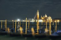 Góndolas borrosas frente a la iglesia de San Giorgio Maggiore en la noche, Venecia, Italia - foto de stock