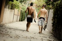 Hommes portant des planches de surf dans la rue de la ville — Photo de stock