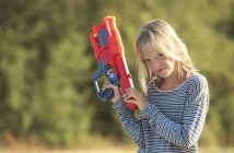 Portrait de fille tenant un pistolet à eau, Buonconvento, Toscane, Italie — Photo de stock