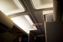 Cierre del cartel de salida en la cabina del avión - foto de stock