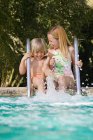 Мальчик и девочка плескаются в бассейне — стоковое фото