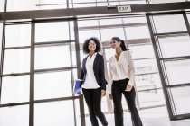 Deux jeunes femmes d'affaires arrivant à l'entrée du bureau — Photo de stock