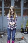 Chica en jardín ventosas semillas en las manos - foto de stock