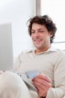Man shopping online in living room — Stock Photo