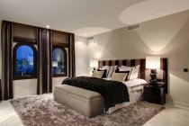 Кровать и окна в современной спальне — стоковое фото