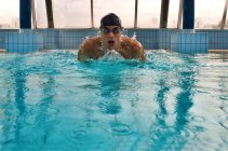 Мужчина плавает в закрытом бассейне — стоковое фото