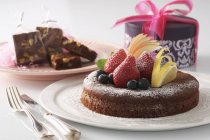 Торт украшен свежими фруктами подается на тарелке — стоковое фото