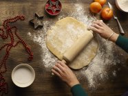 Imagem cortada de adolescente rolando massa para biscoito estrela de Natal — Fotografia de Stock