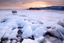 Blick auf Geländewagen und Oltrek-Insel bei Sonnenuntergang, Baikalsee, Olchon-Insel, Sibirien, Russland — Stockfoto