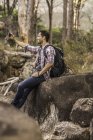 Male hiker taking smartphone selfie on forest rock formation, Deer Park, Cape Town, South Africa — Stock Photo