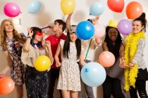 Friends at a party with balloons, studio shot — Stock Photo