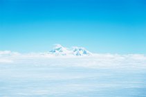 Снігопадний гірський пік в оточенні хмар — стокове фото
