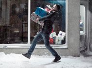 Man carrying Christmas gifts in snow — Stock Photo